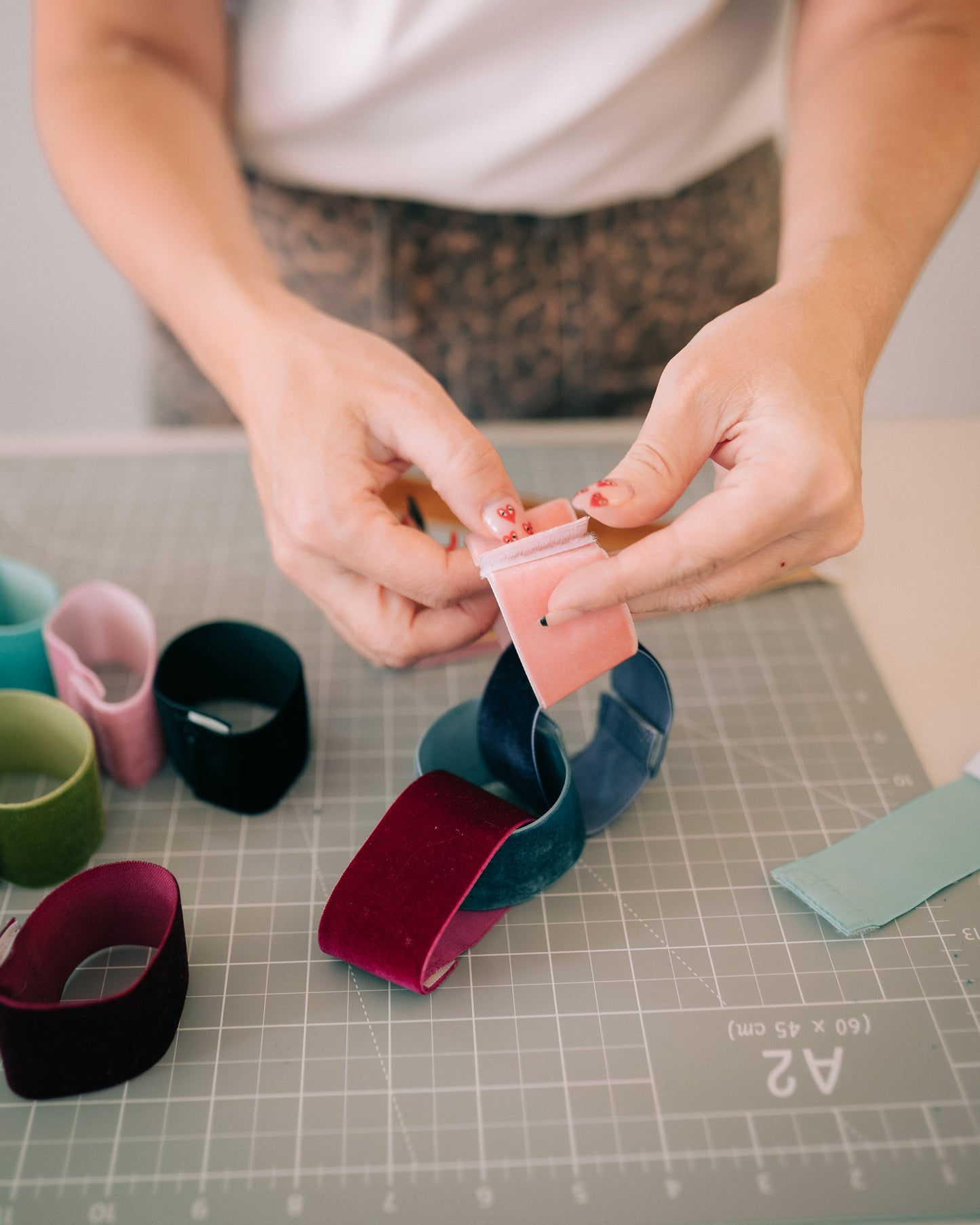 Person working with colorful paper strips on a cutting mat